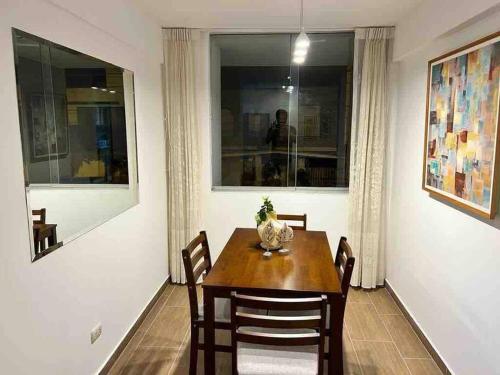 een eetkamer met een tafel en stoelen en een raam bij Cozy Family Full Apartament Excelent WIFI in Lima