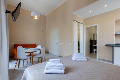 um quarto com uma cama com toalhas brancas em Bonnystudios Holiday Apartments em Cagliari