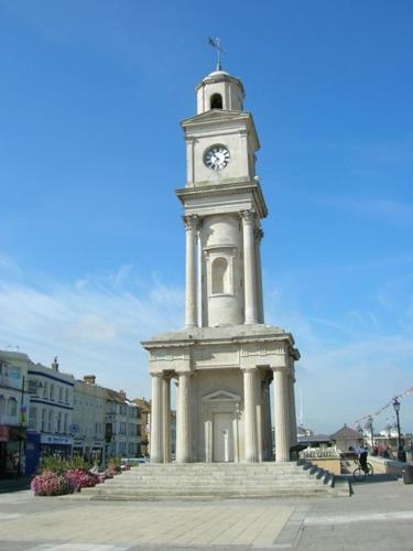 a white clock tower with a cross on top of it at Seaside Villa on Secluded Green in Herne Bay