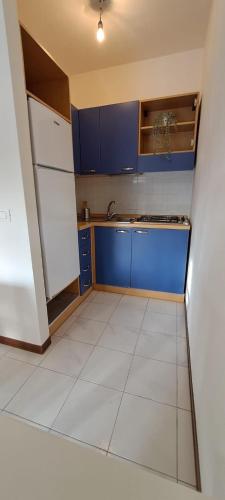 eine Küche mit blauen Schränken und weißem Fliesenboden in der Unterkunft Casa Emma in Suvereto