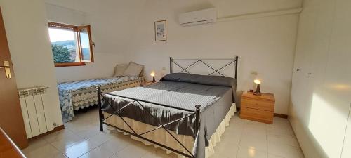 ein Schlafzimmer mit einem Bett, einer Kommode und einem Fenster in der Unterkunft Casa Emma in Suvereto