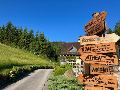 a road with directional signs in front of a house at Guffertblick in Achenkirch