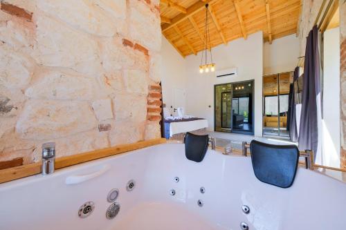 a bath tub in a room with a stone wall at Fethiye Villa Ka Exclusive 1 in Fethiye