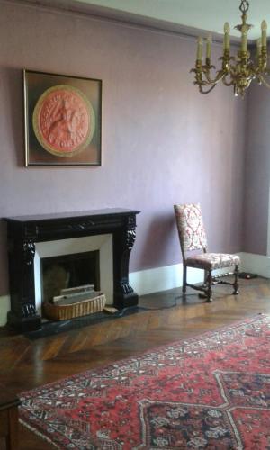 - un salon avec une chaise et une cheminée dans l'établissement Chambre d'hôte d'une maison de chanoine - pas un hôtel, 2e étage, 3 pièces 90m2, à Autun