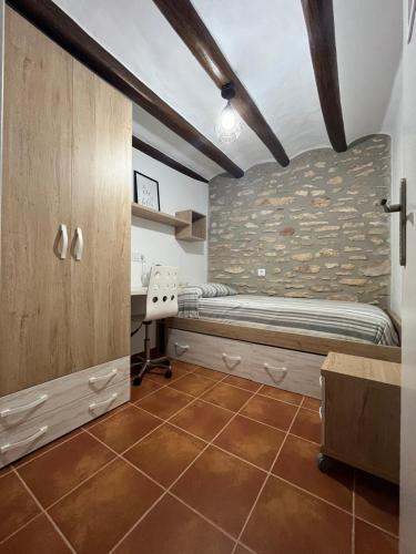 ein Schlafzimmer mit einem Bett und einem Schreibtisch in einem Zimmer in der Unterkunft Ca la Beata in Cálig
