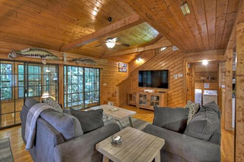 a living room with a couch and a tv in a cabin at Keepin it Reel in Ellijay