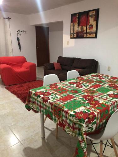 El sueño de Maria في فيراكروز: غرفة معيشة مع طاولة عليها بطانية عيد الميلاد