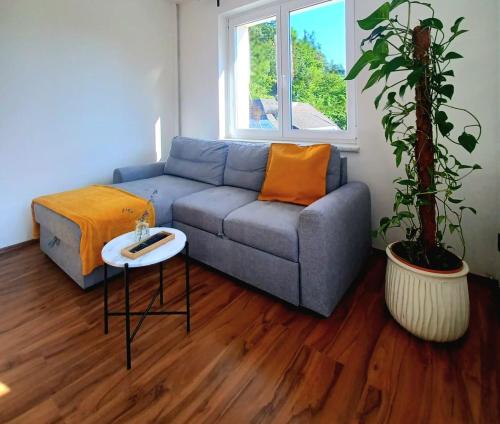 a living room with a blue couch and a table at Ferienwohnung Lucia in Schiefling am See