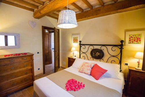 una camera da letto con un grande letto con fiori rossi di BorgoCuore a Todi