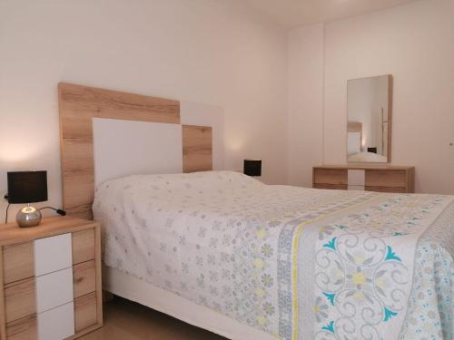 1 dormitorio con 1 cama grande y espejo en Apartamento Moya - Playa y Sol, en Aguadulce