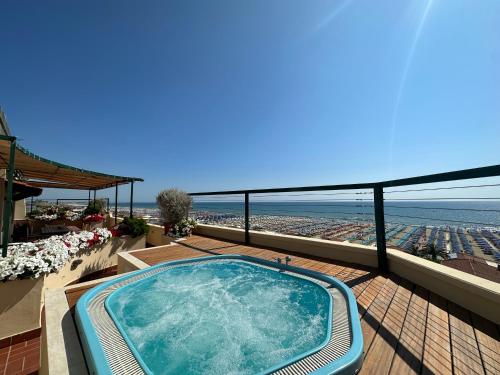 a hot tub on a balcony with a view of the beach at Piccadilly Penthouse with Jacuzzi in Lido di Camaiore