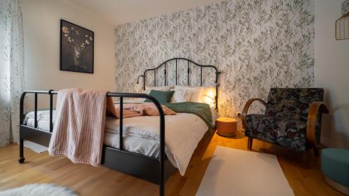 a bedroom with a black bed and a chair at Apartmani Gruzdovo in Delnice