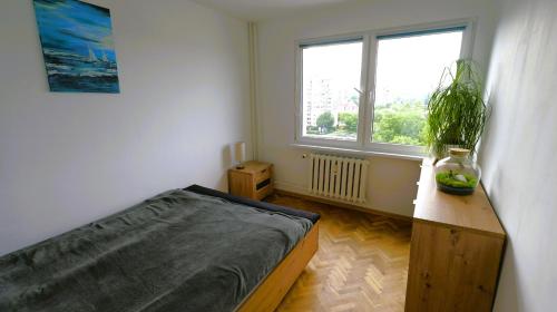 um quarto com uma cama e uma janela em Apartament w centrum Kołobrzegu, nad rzeką em Kolobrzeg