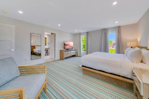 um quarto de hotel com uma cama e um sofá em Mahalo Cape May Townhomes em Cape May