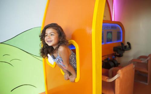 a little girl playing in a toy train at Seabel Aladin Djerba in Aghīr