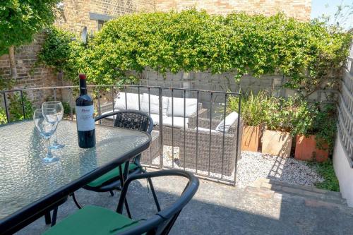 a bottle of wine sitting on a table with a glass at Elegant Family Townhouse-Conservation Area-Garden in Kent