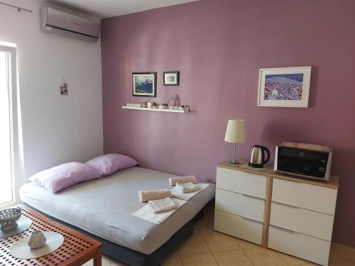 a small bedroom with a bed and a tv at Apartment Stiller in Novalja