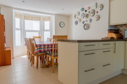 a kitchen and dining room with a table and plates on the wall at Elegant Family Townhouse-Conservation Area-Garden in Kent
