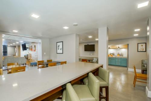 a living room with a large white counter and chairs at Country Inn & Suites by Radisson, New Orleans I-10 East, LA in New Orleans