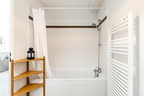 La salle de bains est pourvue d'une douche et d'une baignoire avec rideau de douche. dans l'établissement Élégant appartement à deux pas du Vélodrome - Emplacement idéal à Marseille, à Marseille