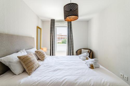 une chambre avec un grand lit blanc avec une fenêtre dans l'établissement Élégant appartement à deux pas du Vélodrome - Emplacement idéal à Marseille, à Marseille