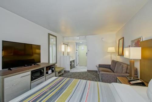 a hotel room with a bed and a flat screen tv at Country Inn & Suites by Radisson, New Orleans I-10 East, LA in New Orleans