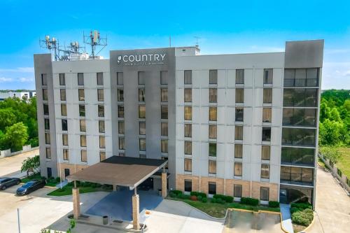 a building with a sign on top of it at Country Inn & Suites by Radisson, New Orleans I-10 East, LA in New Orleans