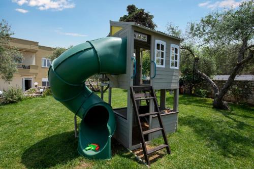 a play house with a slide in a yard at Valia's House in Kato Daratso