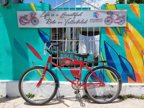a red bike parked in front of a building at Hostal Guacamayas in Valladolid