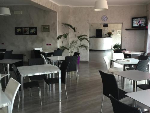 a dining room with white tables and chairs at Hotel Letizia in Follonica