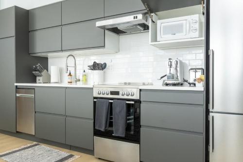 a white kitchen with a stove and a refrigerator at Station Inn Pawling in Pawling