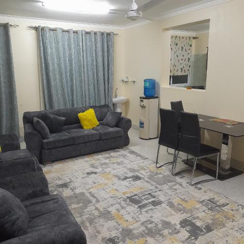 a living room with a couch and a table and chairs at Chloe Isla Apartment Malindi. in Malindi