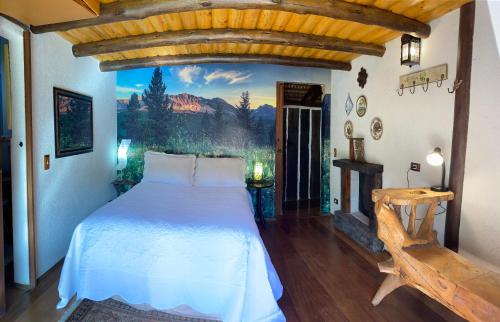 1 dormitorio con 1 cama y una pintura en la pared en Cabana Do Zuza, en Campos do Jordão