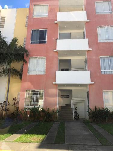 un bâtiment rouge avec des escaliers et un palmier dans l'établissement Depto real del palmar, à Aguacatillo