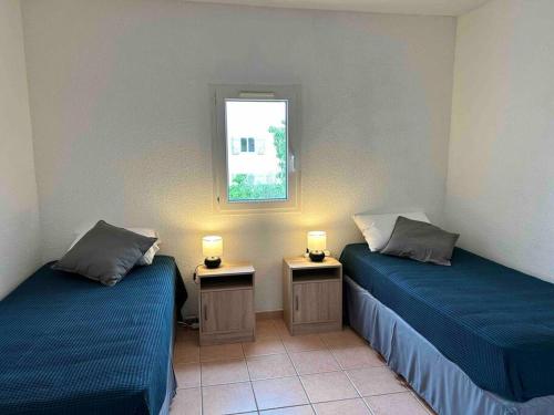 twee bedden in een kamer met twee lampen erop bij Charmante maison à nbne plage in Narbonne