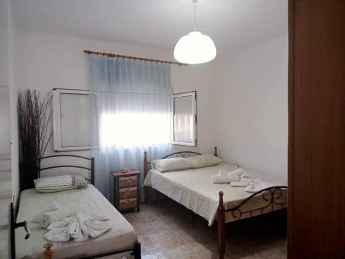 a bedroom with two beds and a window at COUNTRY HOUSE IN OLIVE GROVE - Gerakini in Yerakiní