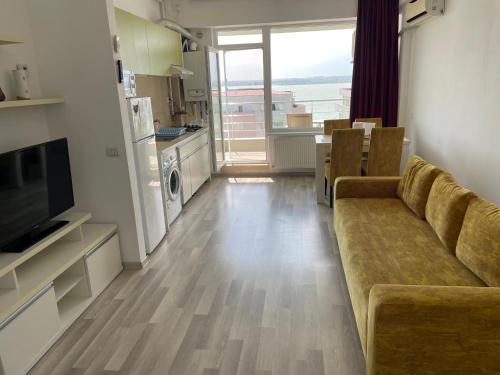 a living room with a couch and a kitchen at Apartament Summerland Crazy Beach Mamaia in Mamaia