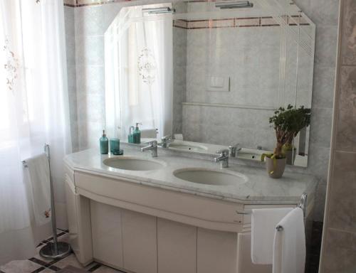 een badkamer met 2 wastafels en een raam bij Ai Cantarelli in Lugagnano