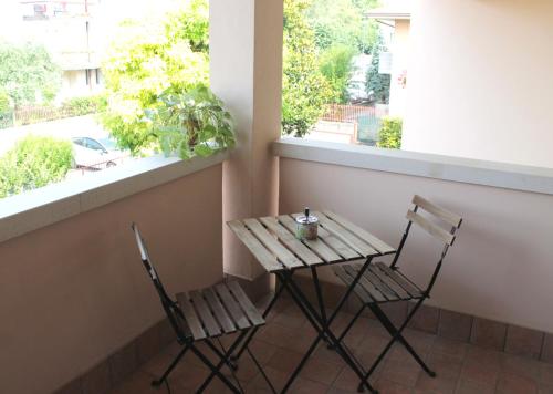 stół i 2 krzesła na balkonie z oknem w obiekcie Ai Cantarelli w mieście Lugagnano