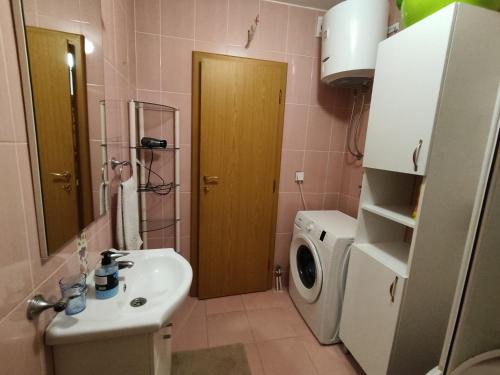 a bathroom with a sink and a washing machine at Stan na dan Brcko MBRadic zgrada in Brčko