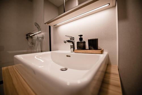 a white bathroom sink with a bottle on it at Sodoben apartma v centru Ljubljane in Ljubljana