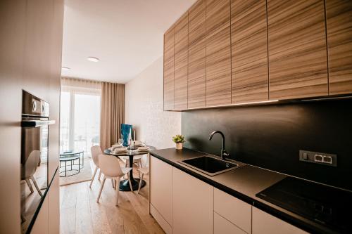 a kitchen with a sink and a table with chairs at Sodoben apartma v centru Ljubljane in Ljubljana