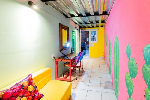 a room with a yellow couch and a pink wall at Casa Colibrí Malecón in Puerto Vallarta