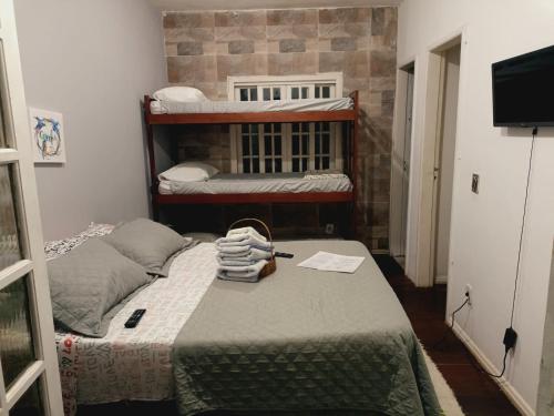a small room with two bunk beds and a television at Pousada Kundalini Arraial in Arraial do Cabo