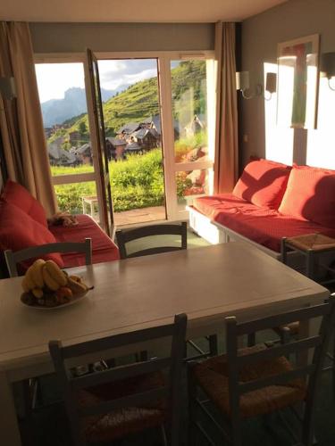 un salon avec une table, des chaises et un canapé dans l'établissement Appartement montagne Valmeinier 1800, à Valmeinier
