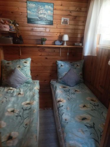 a small room with two beds in a cabin at Domki Obok Ruin in Trzęsacz