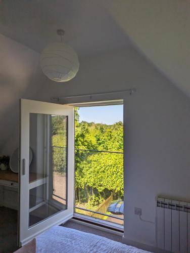 a bedroom with a large window with a view at Myrtle Stables - converted, self-contained, countryside in Hernhill