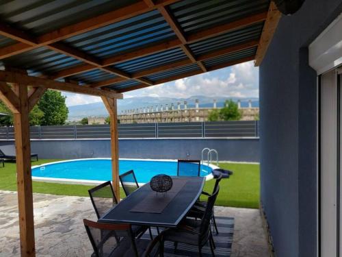 a patio with a table and chairs and a pool at Country house Angela in Košute