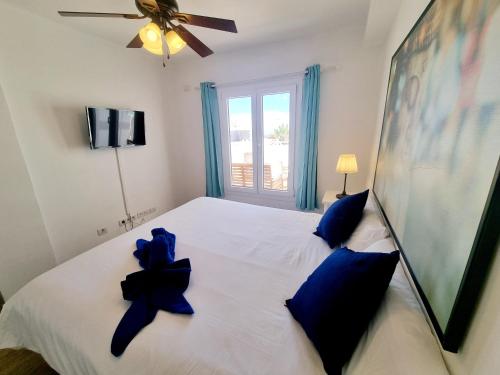 1 dormitorio con 1 cama blanca grande con almohadas azules en Flower Beach 14, en San Bartolomé
