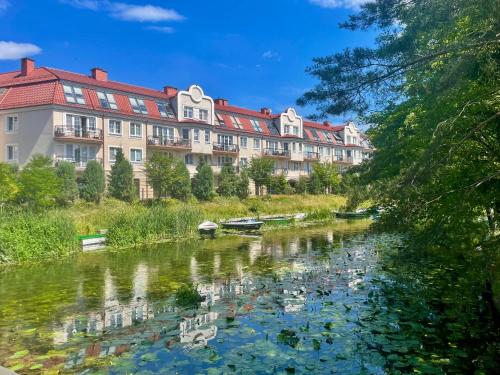 a view of a river in front of a building at Nowoczesny Apartament z widokiem na rzekę i jezioro in Ełk